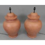A pair of teracotta lamps, 56cm high (2)