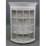 A George III style white painted bowfronted wall hanging corner cabinet with glazed door, 91cm high.