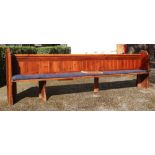 A long Victorian stained pine pew, 335cm