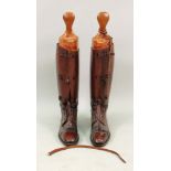 A pair of vintage brown leather lace up riding boots with wooden trees.