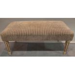 A 20th century cream and gilt painted rectangular footstool on reeded tapering supports,