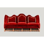 A large Queen Anne style wing back sofa, with triple hump back, on red stained turned supports,