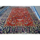 A Heriz carpet, Persian, the madder field with three central angular vases of flowers,