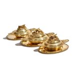 A set of three silver gilt lidded dishes and stands, the larger dish decorated with birds,