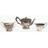 Silver tea wares, comprising; a teapot with black fittings, Sheffield 1910,