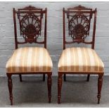 Four late Victorian carved walnut side chairs, each with stylized shell and fan back,