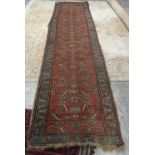 A North West Persian runner, the madder field with an allover herate design,