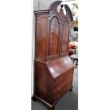 A mid-18th century mahogany bureau cabinet, the broken arch top cornice,