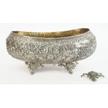 A large boat shaped centrepiece bowl, having floral, foliate and scroll embossed decoration,