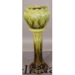 A green glaze Burmantofts jardiniere on stand, 35cm wide x 110cm high.