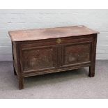 A 17th century oak coffer, the twin plank top over carved double panel front, on stile feet,