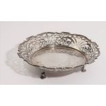 A silver bowl, of shaped circular form, having pierced decoration, raised on three feet,