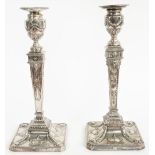 Two similar silver table candlesticks, each with a tapered square section stem,