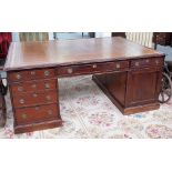 A late Victorian mahogany partners desk with nine drawers about the knee and opposing cupboards,