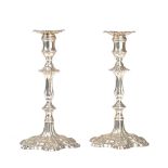 A pair of late George II silver table candlesticks, each or cast form, with shaped stems,
