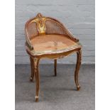 A late 19th century French gilt framed low tub back cellist chair with cane back and seat on scroll