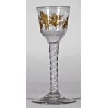 An opaque twist wine glass, circa 1765, the ogee bowl gilded, possibly later, with fruiting vine,