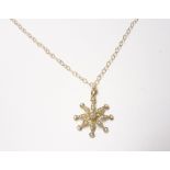 A gold and seed pearl set pendant, designed as an eight pointed starburst, (one seed pearl lacking),