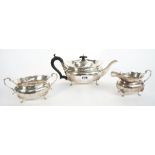 A silver three piece tea set; comprising; a teapot with black fittings,