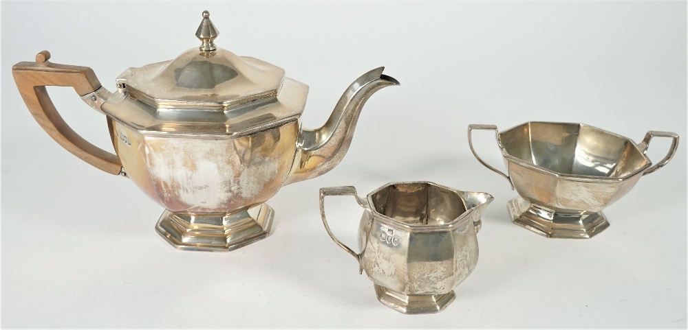 Silver tea wares, comprising; a teapot with a wooden handle, a twin handled sugar bowl,