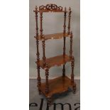 A Victorian walnut four tier serpentine what-not on turned supports, 50cm wide x 128cm high.