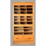 Dudley & Co Ltd; A mid 20th century oak haberdashery cabinet, with three glazed up and over doors,