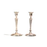 A pair of George III silver table candlesticks, each with a tapered stem, raised on a circular foot,
