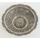 A shaped circular bowl, with embossed scroll and patterned decoration, within a cast border,