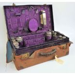 A silver mounted travelling part toilet set, fitted with a variety of bottles, jars,