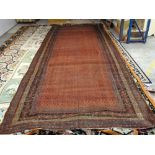 A Saraband long carpet, Persian, the madder field with an allover boteh design,