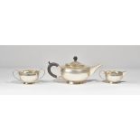 Silver tea wares, comprising; a teapot of squat circular form, having black fittings,