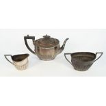 A late Victorian silver three piece tea set, comprising; a teapot with black fittings,