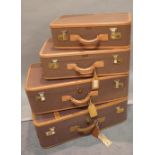 A group of four early 20th century leather bound canvas suitcases,