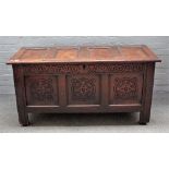 A 17th century oak coffer, with four panel lid and carved triple panel front,