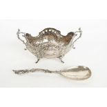A silver twin handled bowl, of shaped oval form, with cast floral and scrolling decoration,