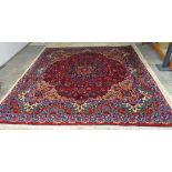 A Mashad carpet, Persian, the dark madder field with a black and madder rosette medallion,