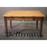 An early 20th century pine and elm kitchen table with single drawer on tapering square supports,