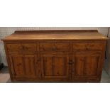 An early 20th century pitch pine dresser base with three drawers over cupboards,