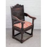 A 17th century oak Wainscot open armchair, with panel square back and solid seat,