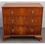 Waring & Gillow Limited; a walnut chest with three long graduated drawers, on ogee bracket feet,