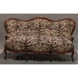 A late 19th century Continental arch back mahogany sofa on cabriole supports,