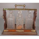 A mid-20th century oak and silver plated mounted tantalus with three 20th century cut glass