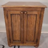 A 20th century oak side cupboard on bun feet, 65cm wide x 81cm high.