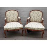 A pair of 18th century Continental oak open armchairs with serpentine seats on scroll supports,