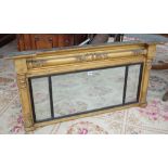 A Regency gilt framed triple plate overmantel mirror, with split column mounts and ebonised slip,