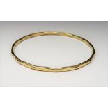 A 9ct gold circular bangle, having faceted decoration, internal diameter 6.5cm, weight 10.5 gms.