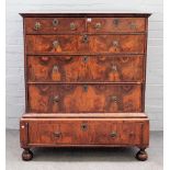 A late 17th century featherbanded walnut chest on stand with two short drawers over three long