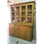 An early 20th century pine dresser with glazed four door top over cupboard base,