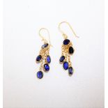 A pair of sapphire set pendant earrings of fringe design, mounted with oval cut sapphires,