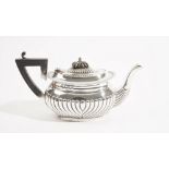 A silver teapot, of oval form, with curved fluted decoration,